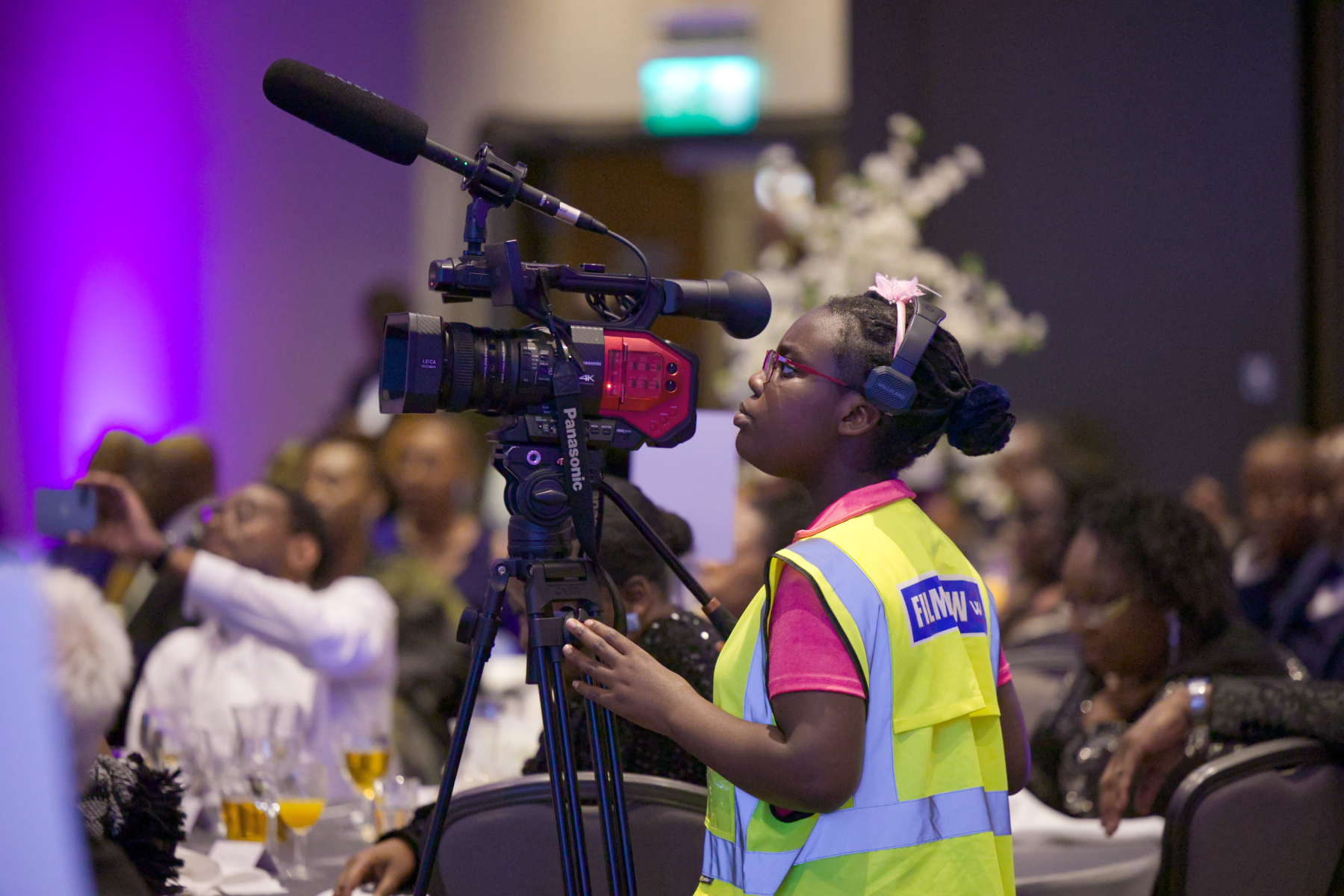 Camera operator filming with professional 4K camera equipment